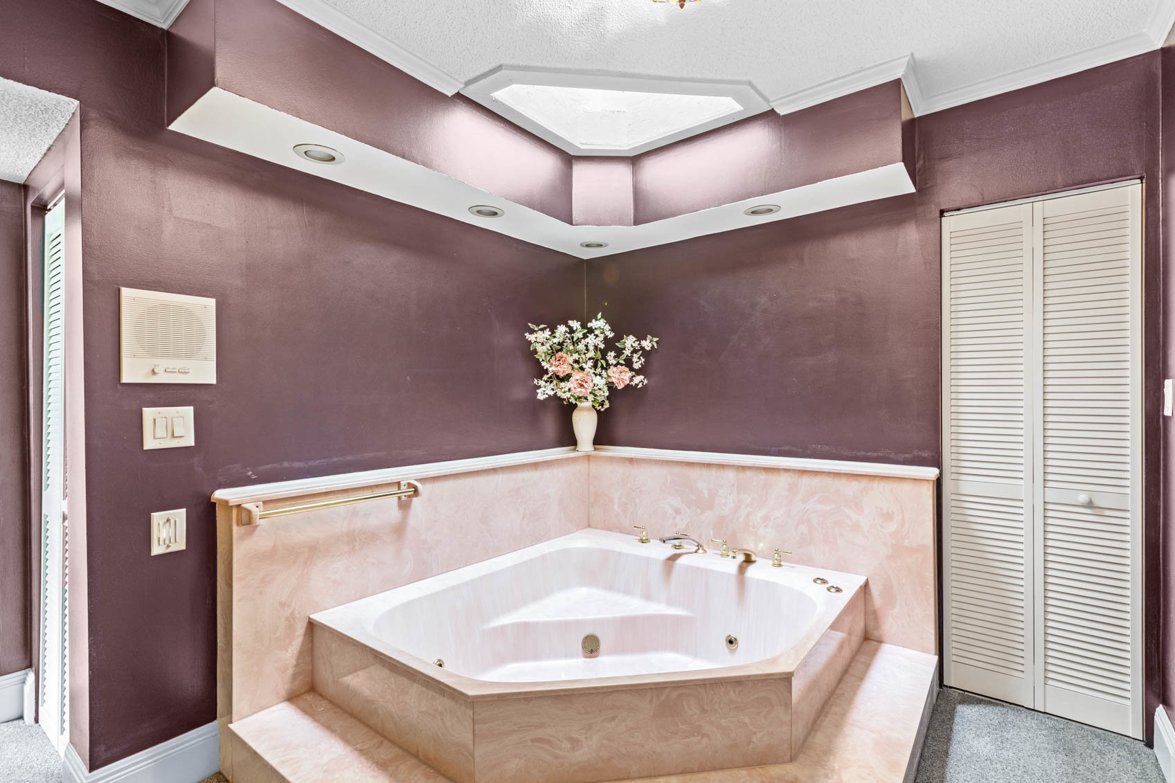 bathroom with large soaker tub and steps